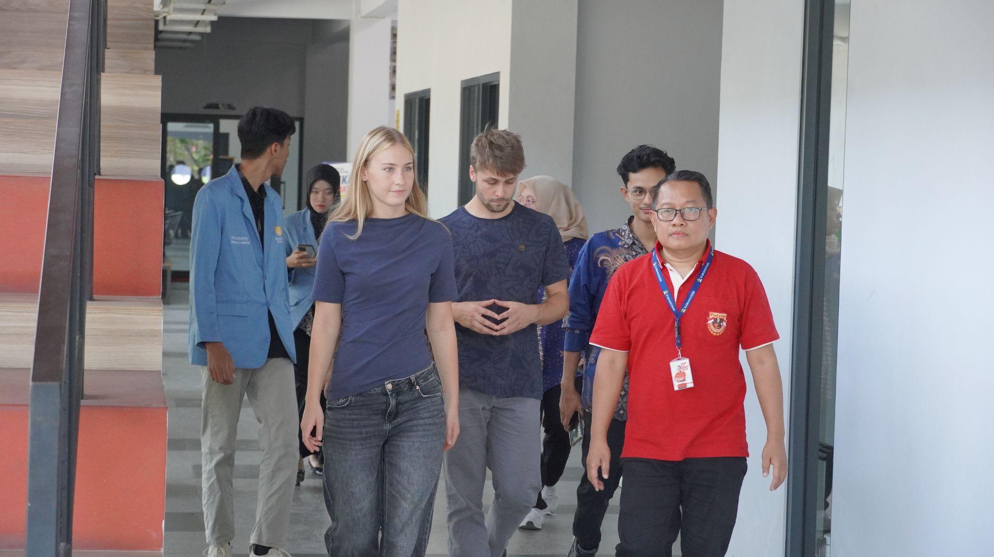 German exchange students walk through Sekolah Karangturi with local student hosts.